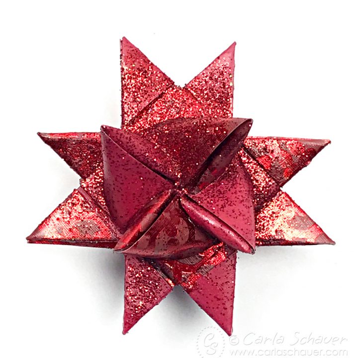 Red Wax Dipped and Glittered Froebel Star Ornamenton white background