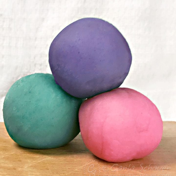 3 balls of multicolored homemade playdough.